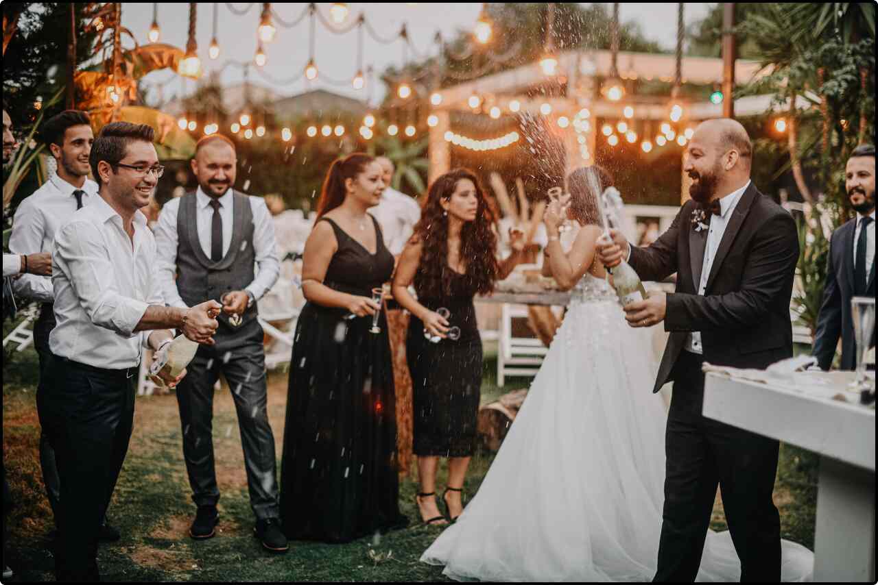 A wedding celebration with attendees performing a traditional ritual using sampen, a ceremonial wooden set, in a beautifully decorated venue.